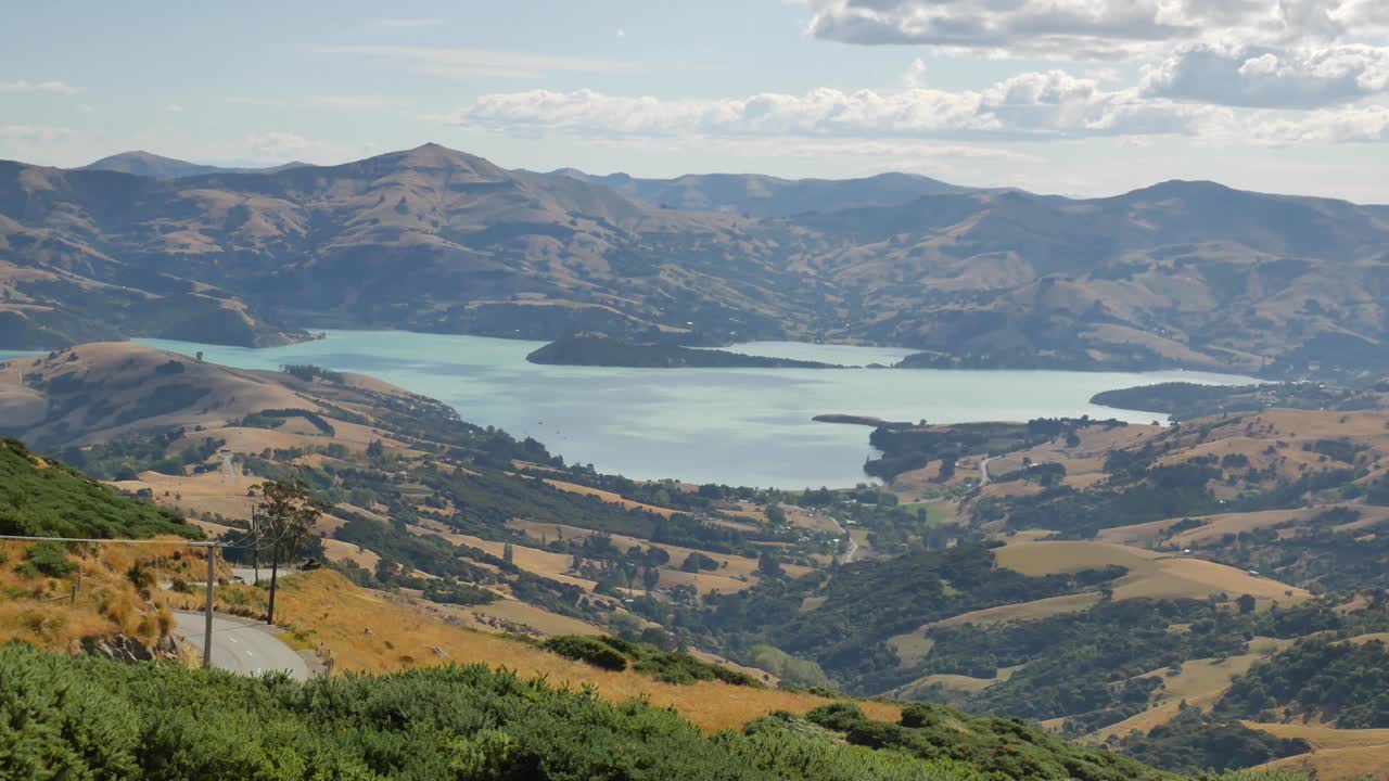 panorama panorámico a través de colinas verdes doradas y entrada de akaroa, nueva zelanda