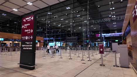 spacious and modern airport terminal featuring travelers walking through the gates, showcasing architectural design and travel ambiance.