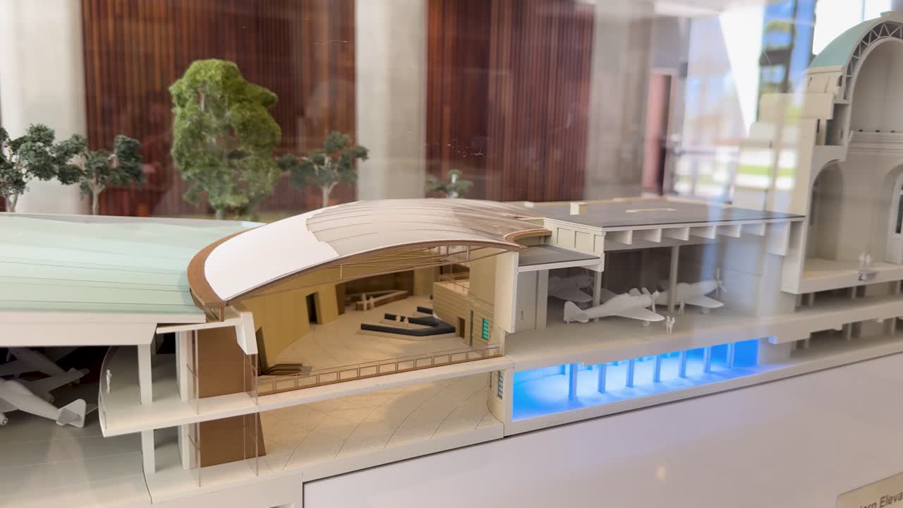 A smooth panning shot reveals a detailed cross-section architectural model with blue interior lighting