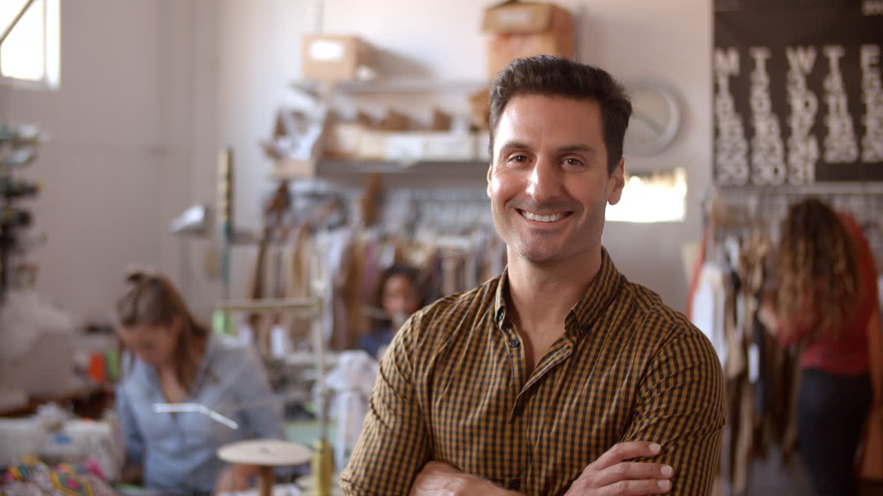 hombre en el estudio de fabricación de ropa entra en el plano focal