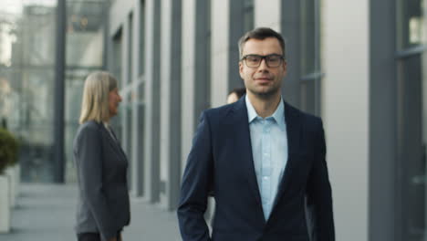 Businessman-Leaving-Business-Partners-And-Coming-Closer-To-Camera-Outdoors