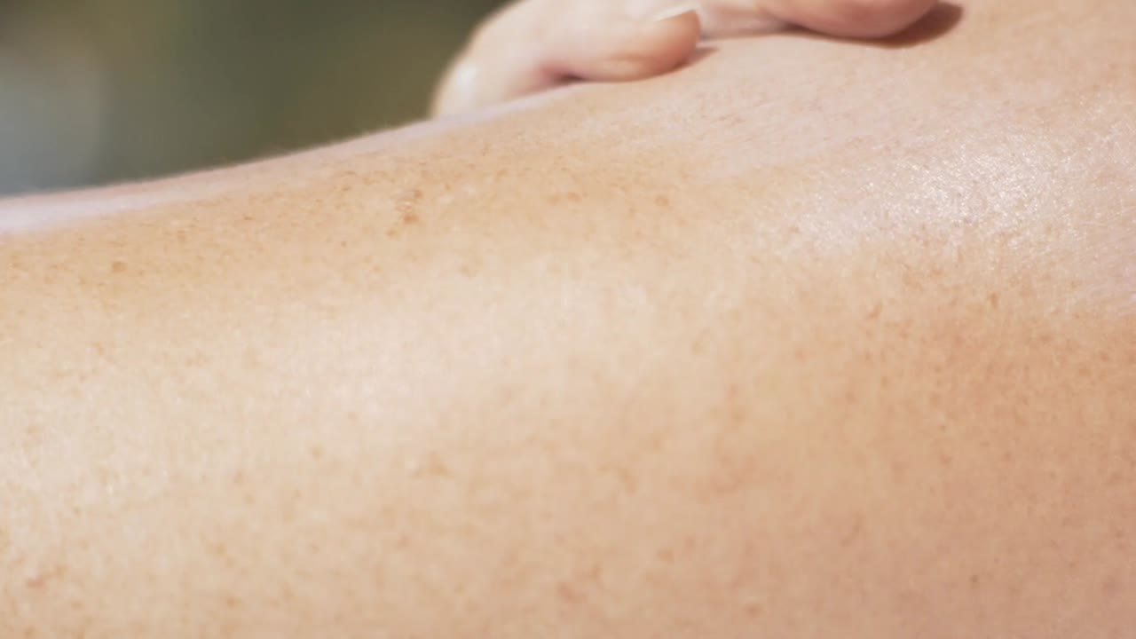 mujer que lubrica bloqueador solar en su mano