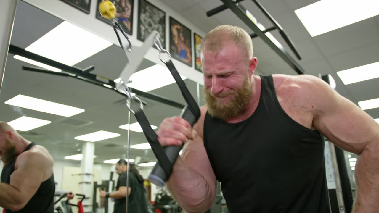 Young Adult Man Strenuously Working Out at Gym