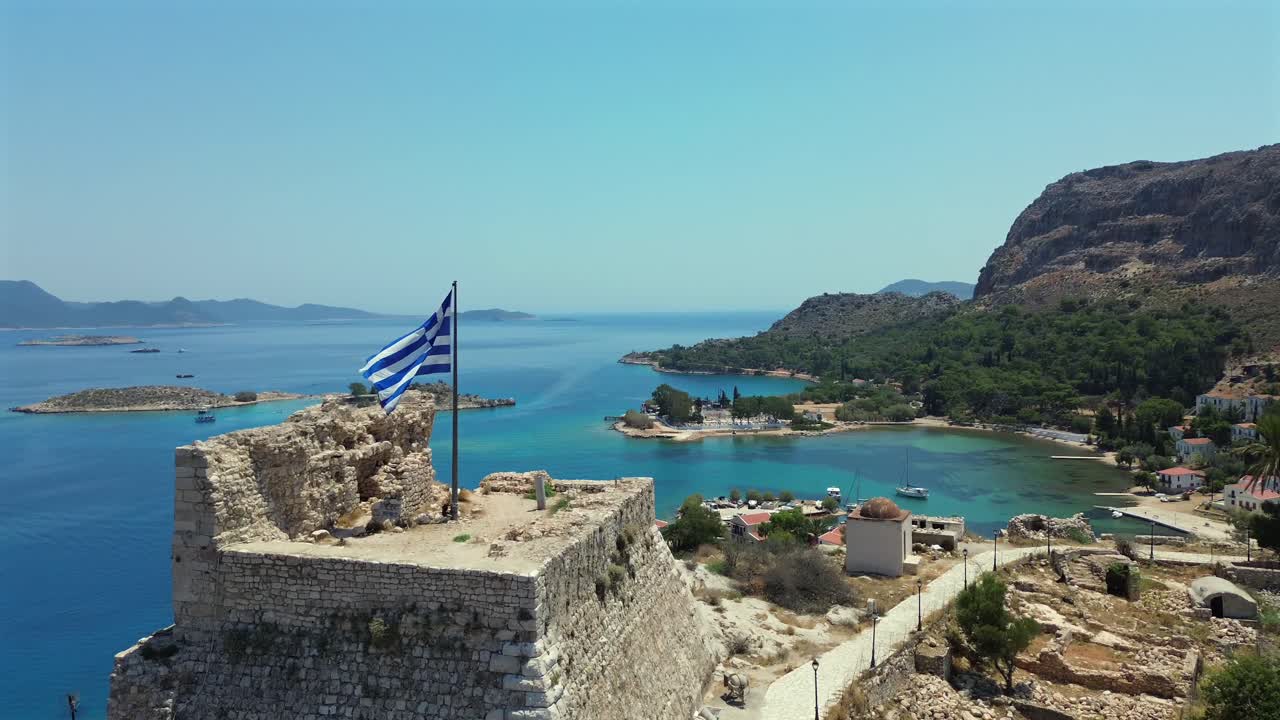 Cinematic drone flyover of the Knights' Castle in Kastellorizo. The shot reveals the small islands near the Turkish border. Breathtaking view of Greek architecture and turquoise Aegean sea