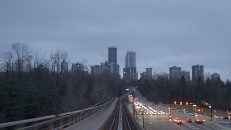 pociąg podróżujący po podwyższonej linii kolejowej w nocy w vancouver w kolumbii brytyjskiej w kanadzie