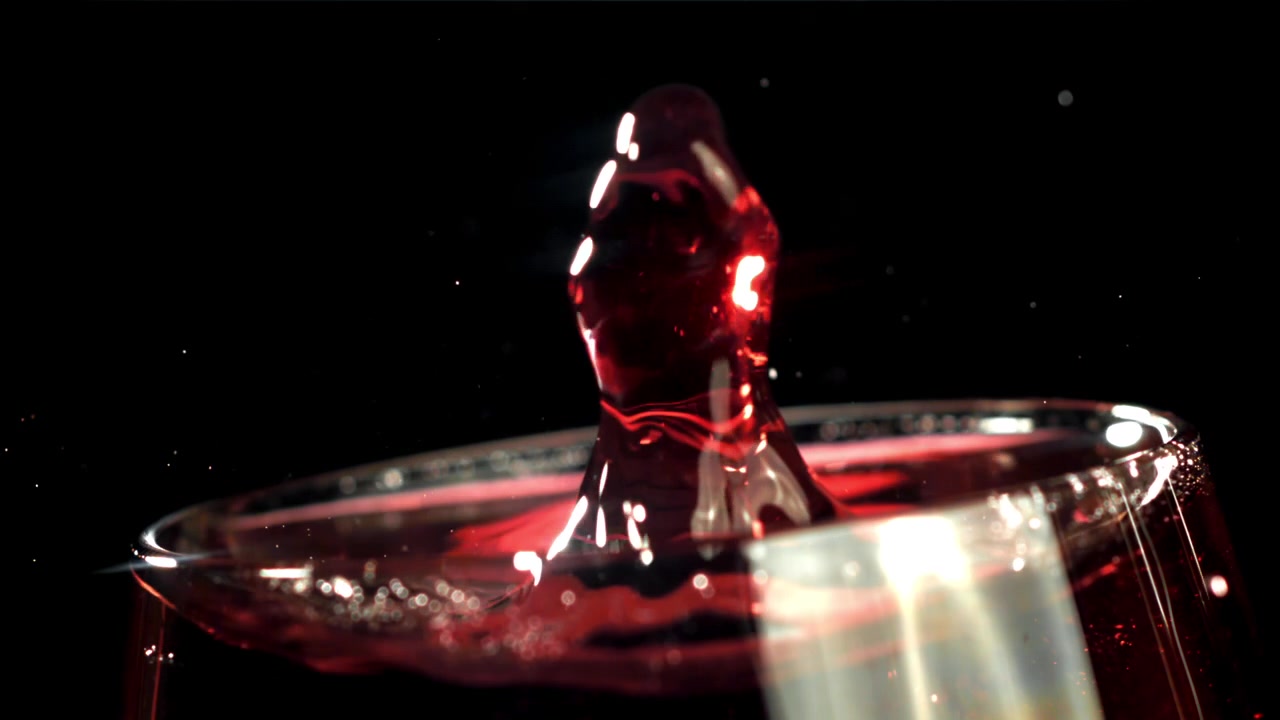 Rød væskedråbe skaber et kroneplask i slowmotion.