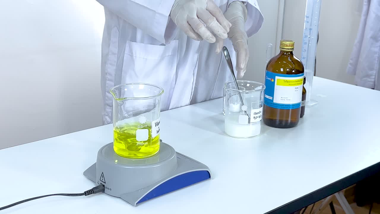 un científico realiza una reacción de reloj de yodo utilizando vitamina c y almidón bajo iluminación controlada en un entorno de laboratorio