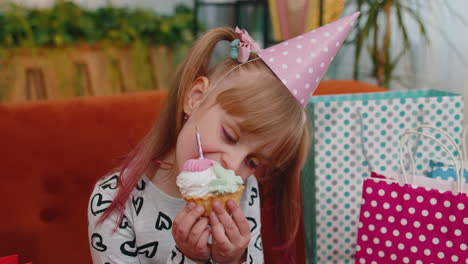 young little children girl sitting on sofa with lots of gifts celebrating birthday party anniversary