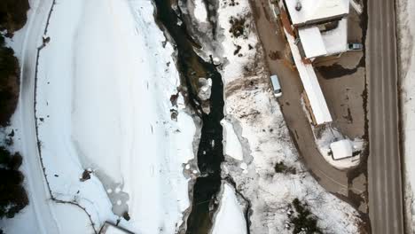 Small-Frozen-River-Bank-in-snowy-landscape-during-wintertime