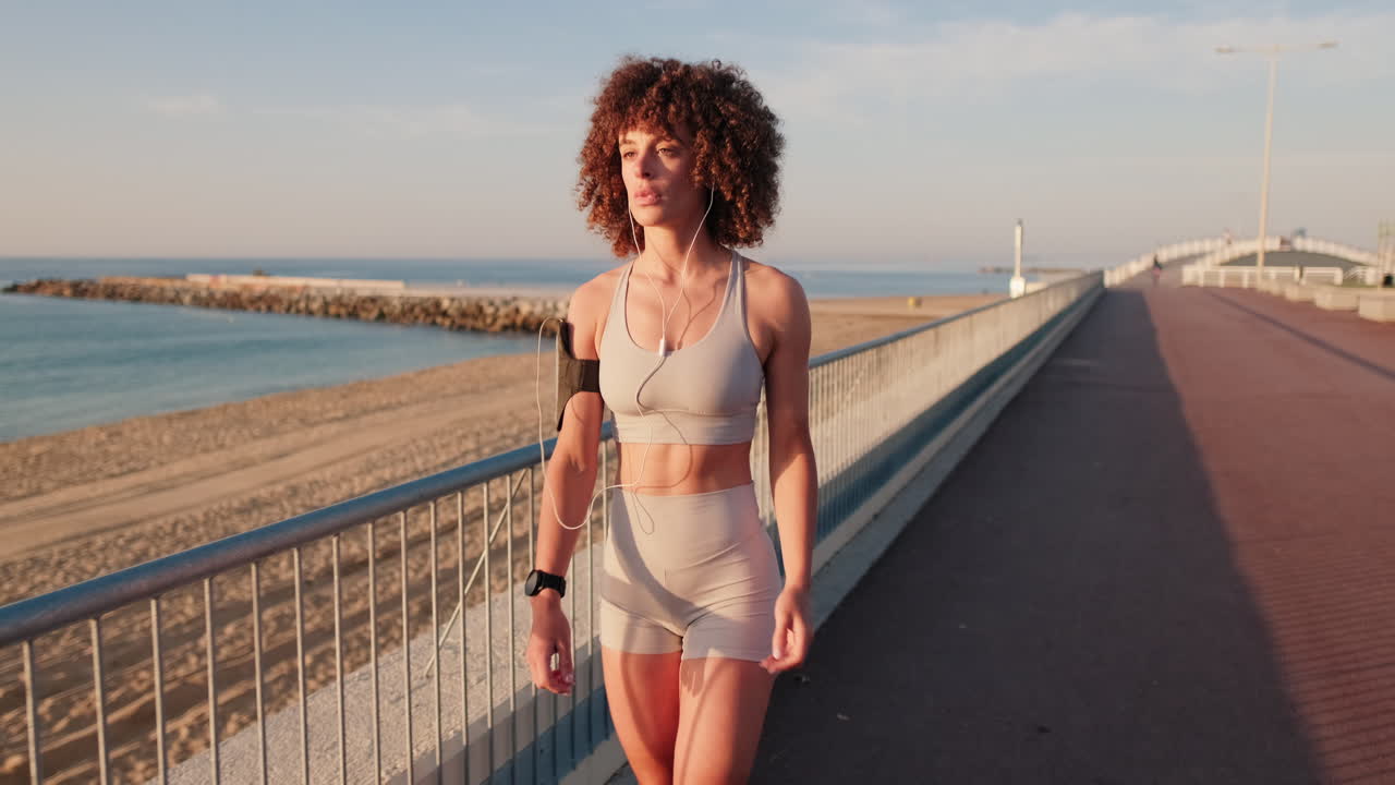 Woman Walking on Beach at Sunrise