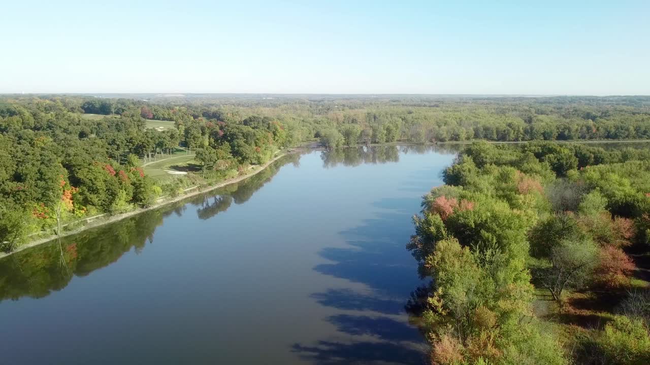 Inquadratura dal basso, veduta lenta da drone che segue il percorso acquatico del fiume Iowa in una soleggiata giornata di fine estate vicino a Iowa City, Iowa.