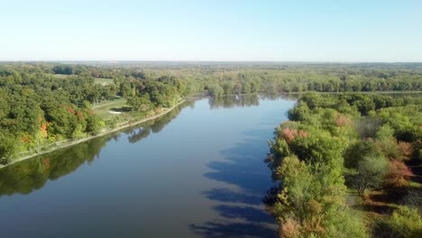 low angle, slow drone view following the iowa river water trail on a sunny late summer day near iowa city iowa