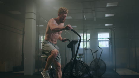 Fitness-man-on-bicycle-doing-spinning-at-gym.-Fit-young-male-working-out-on-gym-bike.-Male-exercising-on-bicycle-in-health-club