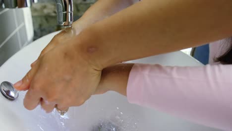 mother and daughter washing hands in bathroom sink 4k