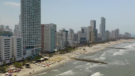 toma aérea fija de olas rompiendo en playa bocagrande en cartagena, colombia