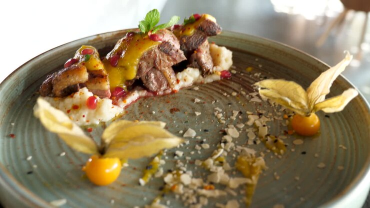 Plat gastronomique avec viande, grenade et groseille du Cap