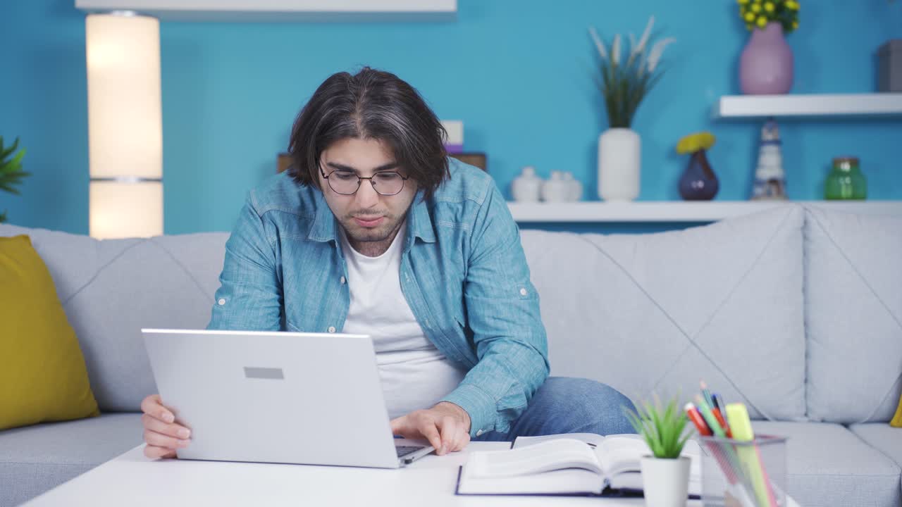 joven exitoso mirando la computadora portátil con alegría y felicidad.