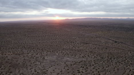 aerial view of the sun setting behind the mountains in arizona