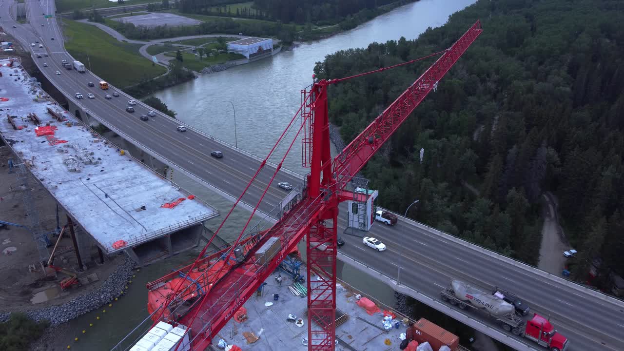 Crane by busy highway bridge construction zone trucking