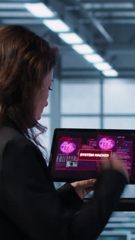vertical video team of server farm employees detecting hacker attacks on tablet, fighting back