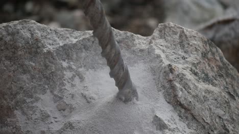 close up of a driller digging a hole into a rock in slow motion