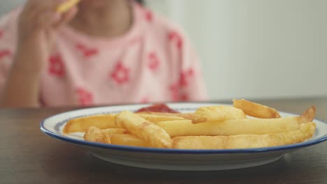 niño comiendo papas fritas