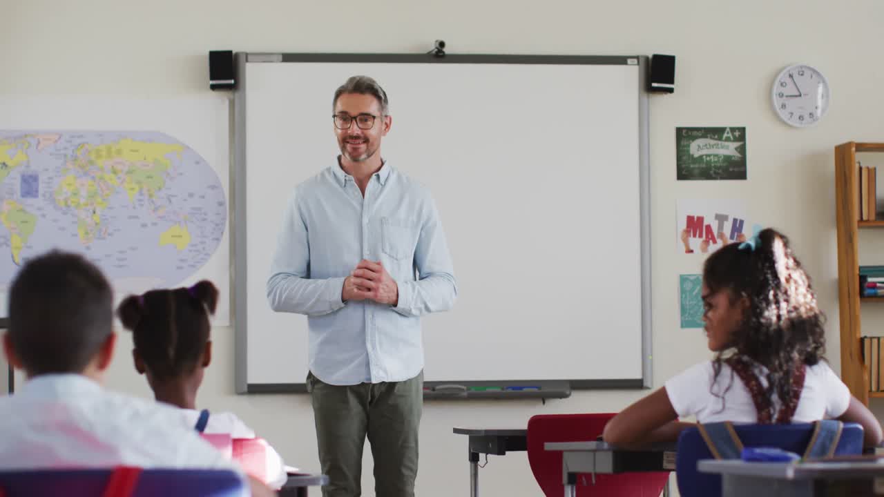 retrato de un feliz maestro caucásico en el aula con los niños durante la lección