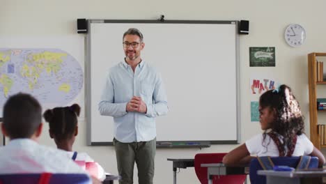 retrato de un feliz maestro caucásico en el aula con los niños durante la lección