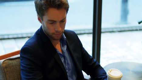 hombre usando una tableta digital mientras bebe café