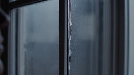 person looking out of a window on a rainy day