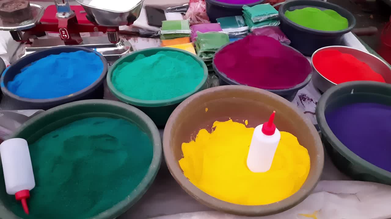 Organic herbal Holi gulaal colors kept in a bowl being sold in a street shop wheelbarrow thela gaadi in Jalgaon, India. Holi is a Hindu festival of colors celebrated in India