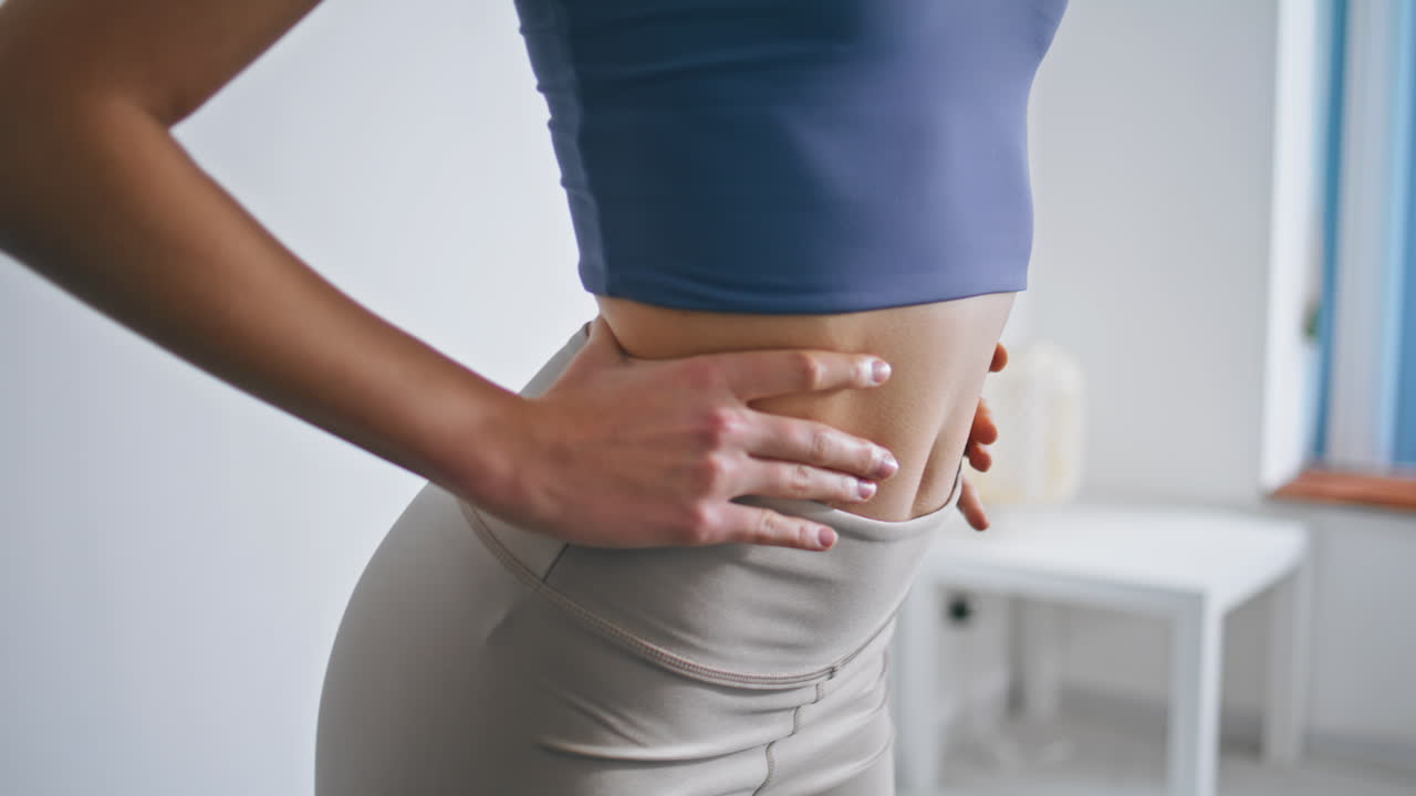 mujer de primer plano girando la cintura entrenamiento en casa. desconocida mujer vientre ejercicios deportivos