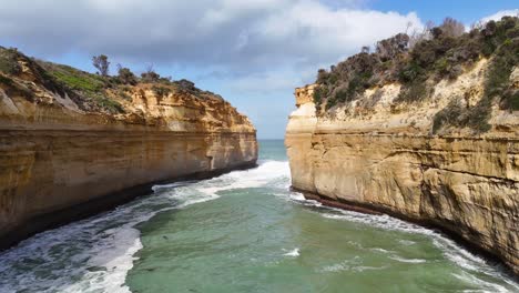 aerial view of dramatic cliffs and ocean waves at loch ard gorge, showcasing natural beauty and dynamic coastal landscape in daylight