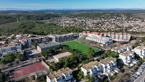 gliding above, la mosson's football field is a patchwork of vibrant greens amids