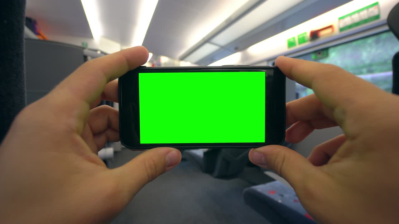 기차에서 초록색 화면으로 전화를 들고 있는 손