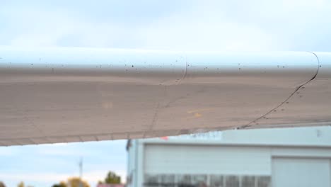 Close-up-of-Cessna-182-main-wing-extending-flaps-at-Colorado-metro-airport,-pan