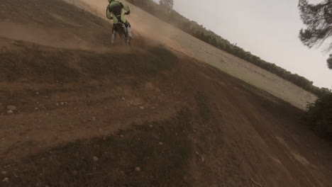 fpv drone chases motocross dirt bike rider on golden sand race track