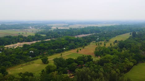 Panoramic-Aerial-View-Of-Lush-Green-Nature-Surroundings-Over-Countryside-Town