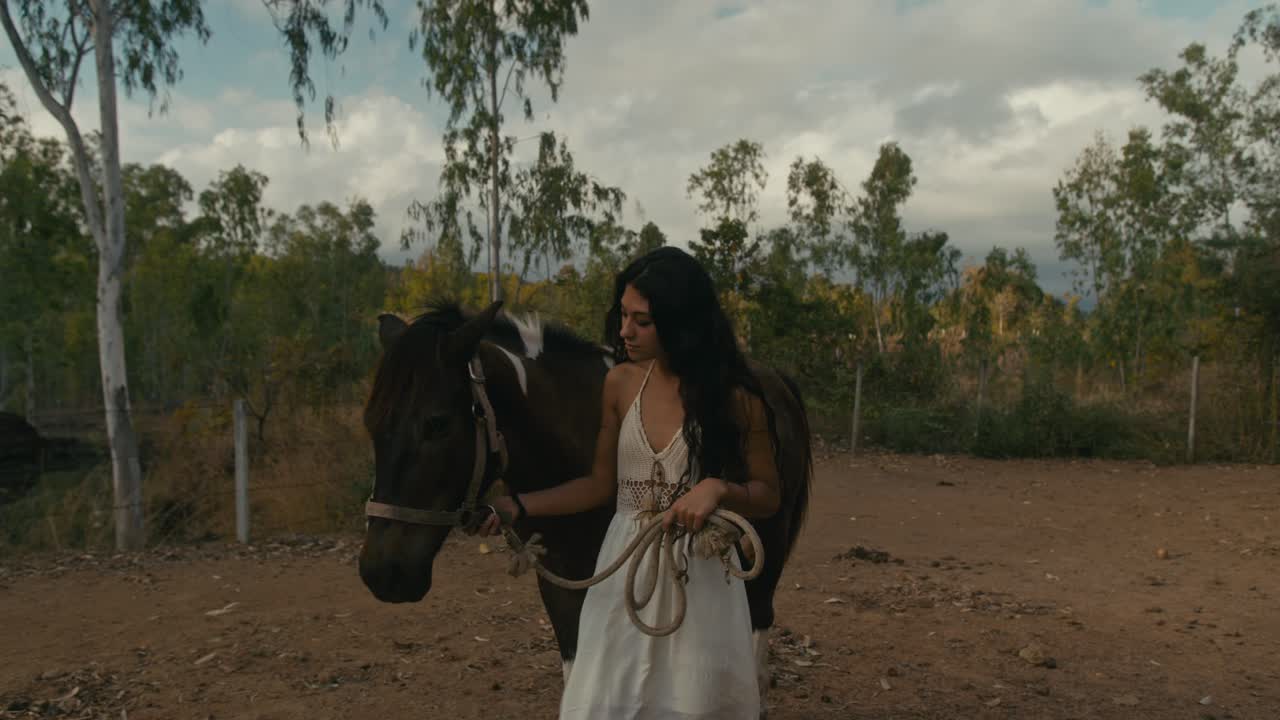 A young woman and her horse in a rural outdoor setting.