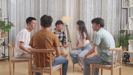 asian teen group sitting in chairs forming a circle arguing and trying to blame each other