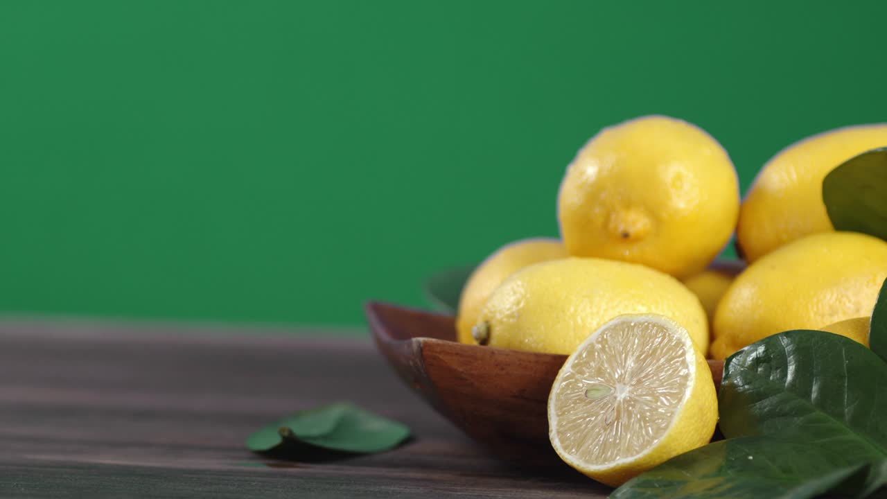 limones jugosos con hojas en el cuenco de madera giran lentamente.