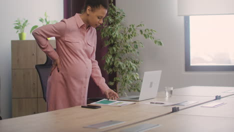 pregnant woman sitting at desk and starting her work day in the office 1