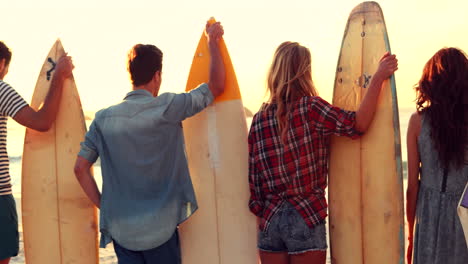 happy friends holding surfboards