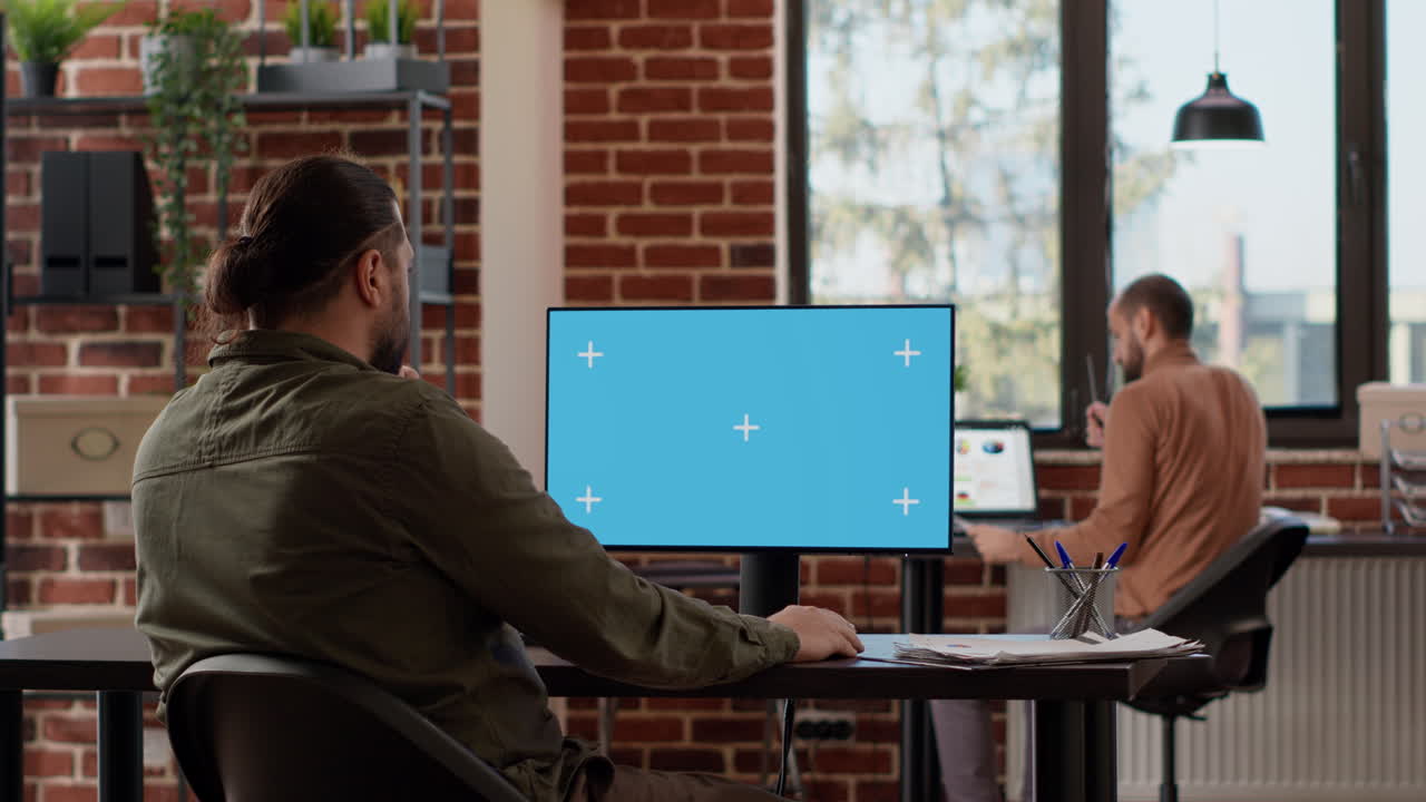 Male freelancer analyzing isolated greenscreen on monitor