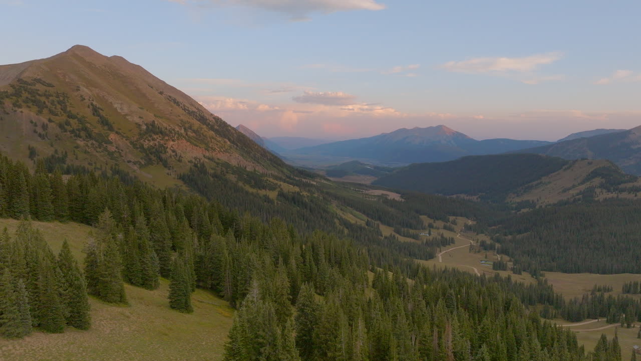 antena sobre árboles en las montañas rocosas de colorado y hacia el pico de una montaña en el horizonte en un hermoso día