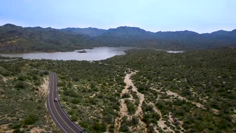 aerial pull back down wash from bartlett lake to desert with a good view of the traffic on the bartlett damn road, tonto national forest, scottsdale, arizona