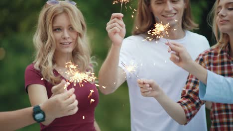 happy friends with sparklers having fun outdoors