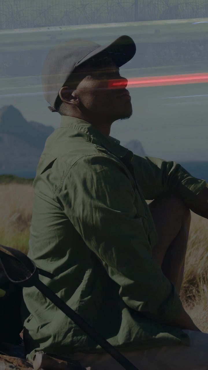 Vertikal video: Mand sidder på klit ved havet, taske og stang til venstre, lysstriber får blikket til at løfte sig for rejse.
