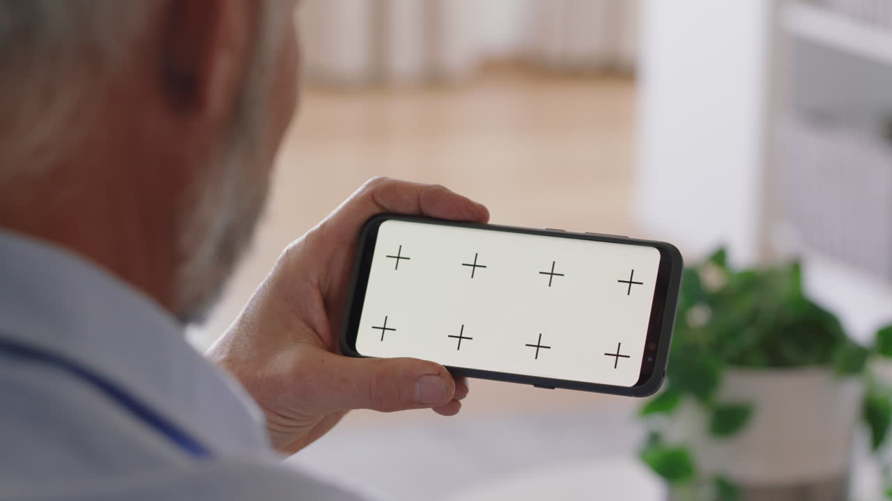 hombre viejo usando un teléfono inteligente pantalla verde teniendo video chat disfrutando de chatear en línea comunicación móvil en pantalla de tecla croma con orientación horizontal