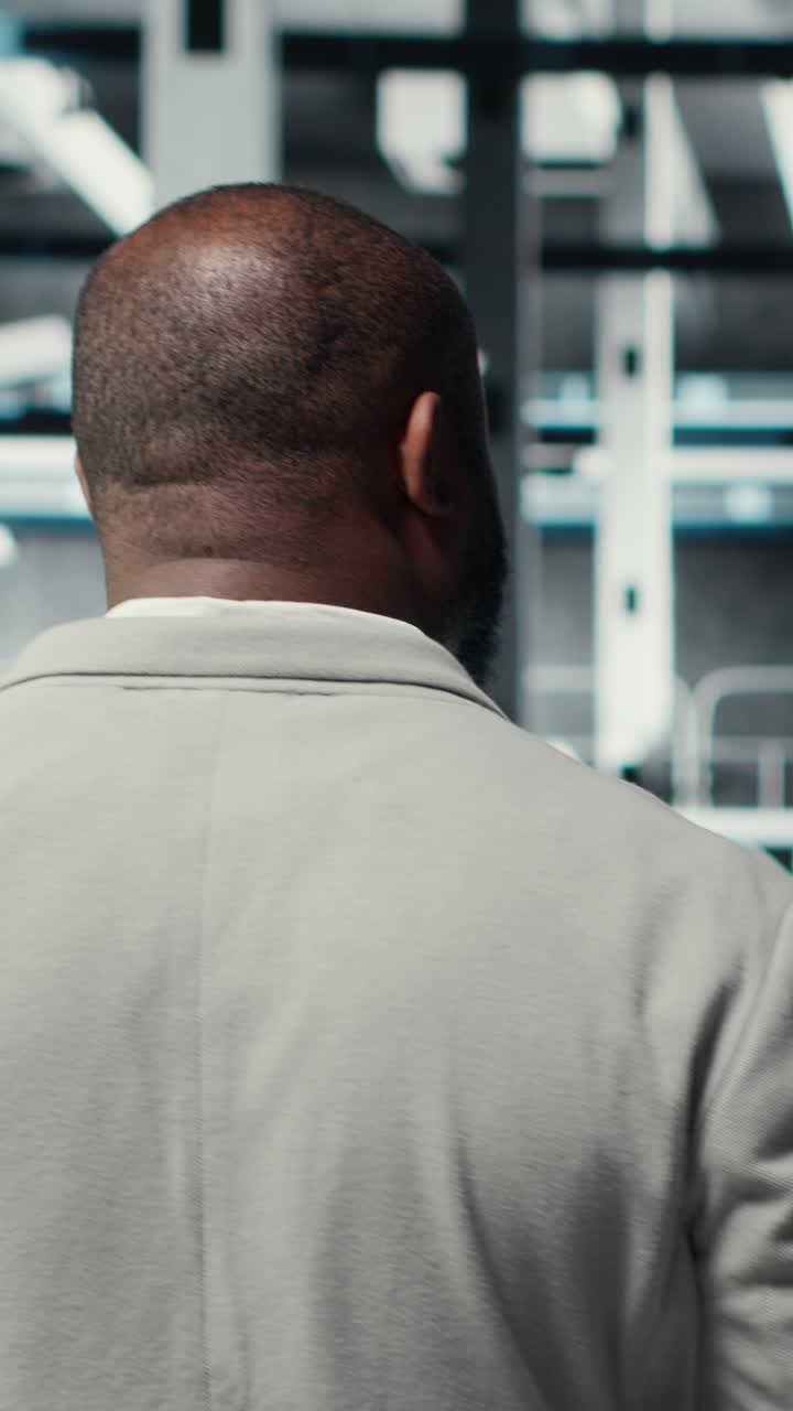 Video verticale Amministratore che cammina in una struttura di data center ad alta tecnologia, che controlla le apparecchiature